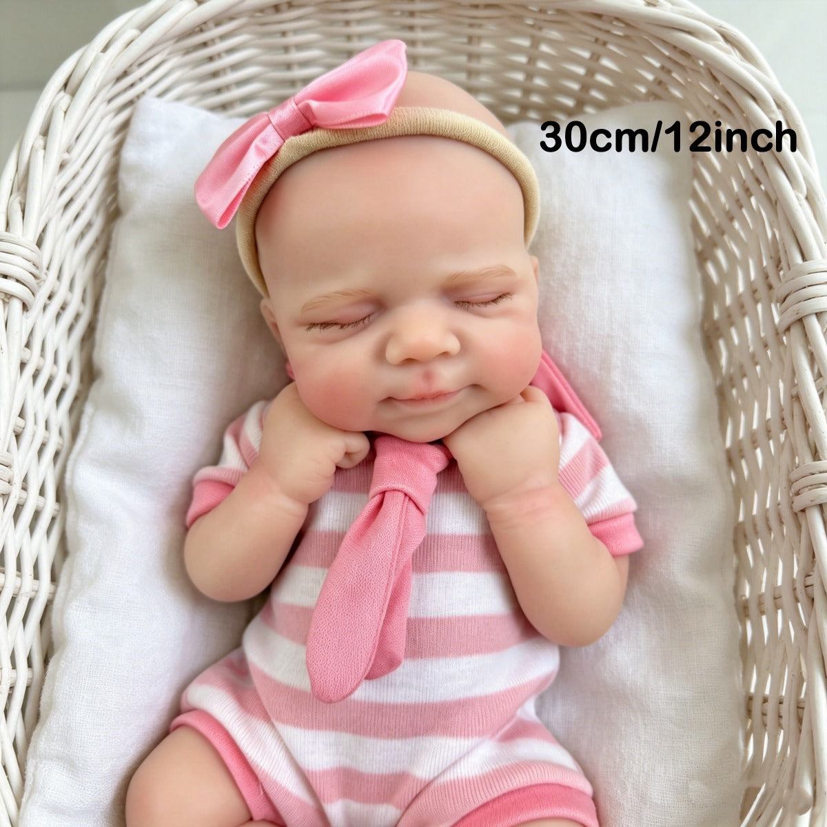 Bambola reborn Pascale in silicone da 30 cm addormentata con indosso un vestitino a righe rosa