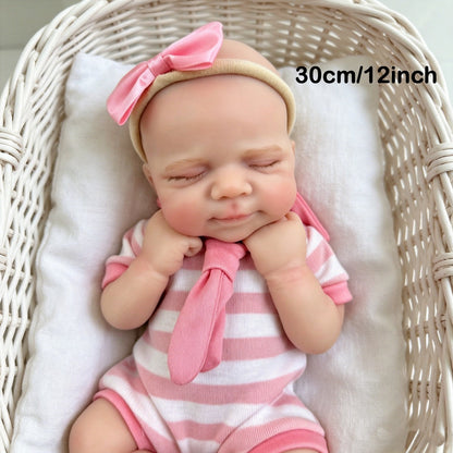 Bambola reborn Pascale in silicone da 30 cm addormentata con indosso un vestitino a righe rosa