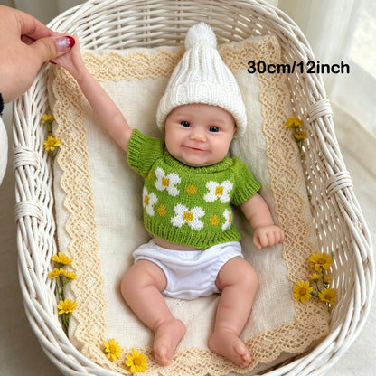Bambola reborn Maddie Smile da 30 cm interamente in silicone con vestitino verde