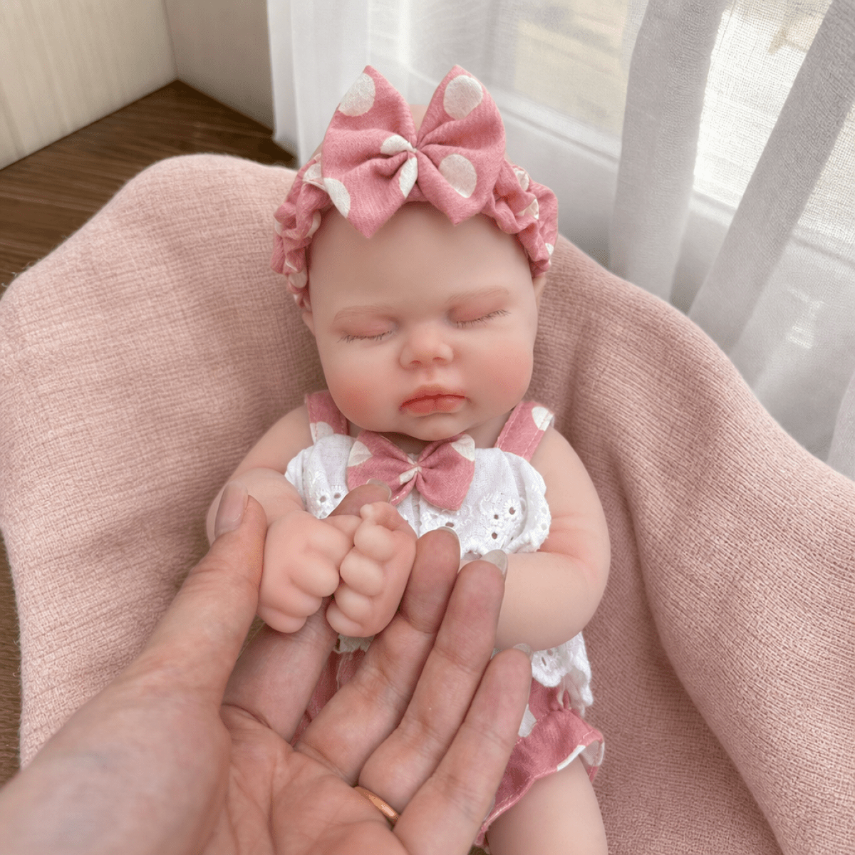 Bambola reborn realistica in morbido silicone alta 30cm con vestitino a pois rosa