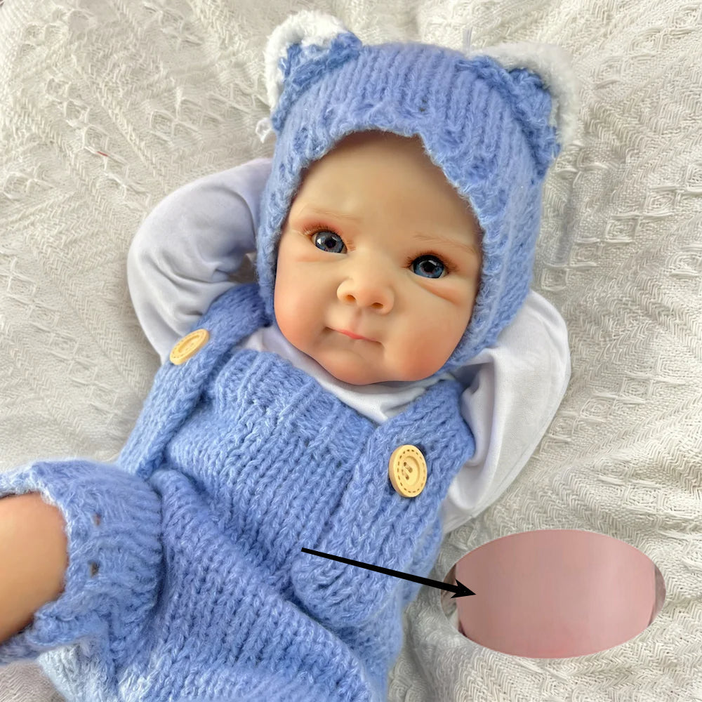 Bambola reborn Bettie da 45cm con occhi azzurri vestita con un body blu lavorato a maglia