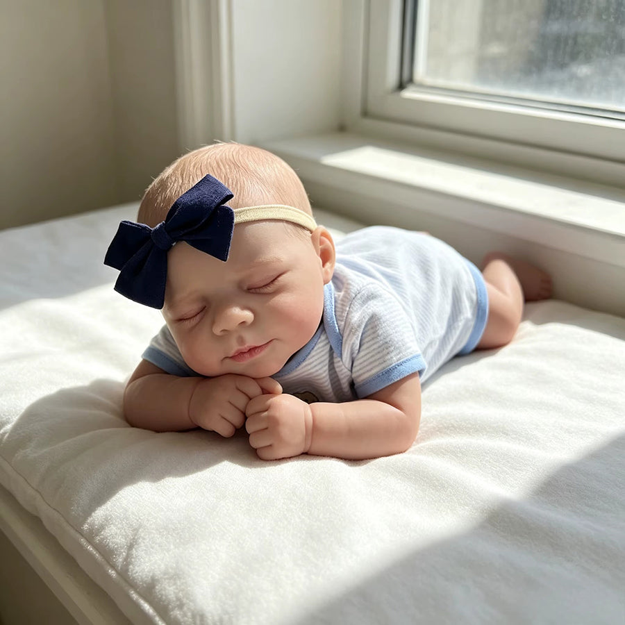 Bambola reborn realistica di 48cm Pascale addormentata con indosso un abito a righe blu