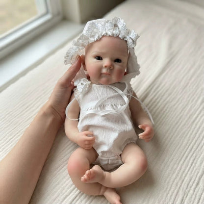 Bambola reborn Bettie da 30cm in silicone con pelle dipinta in 3D e vestitino di pizzo bianco