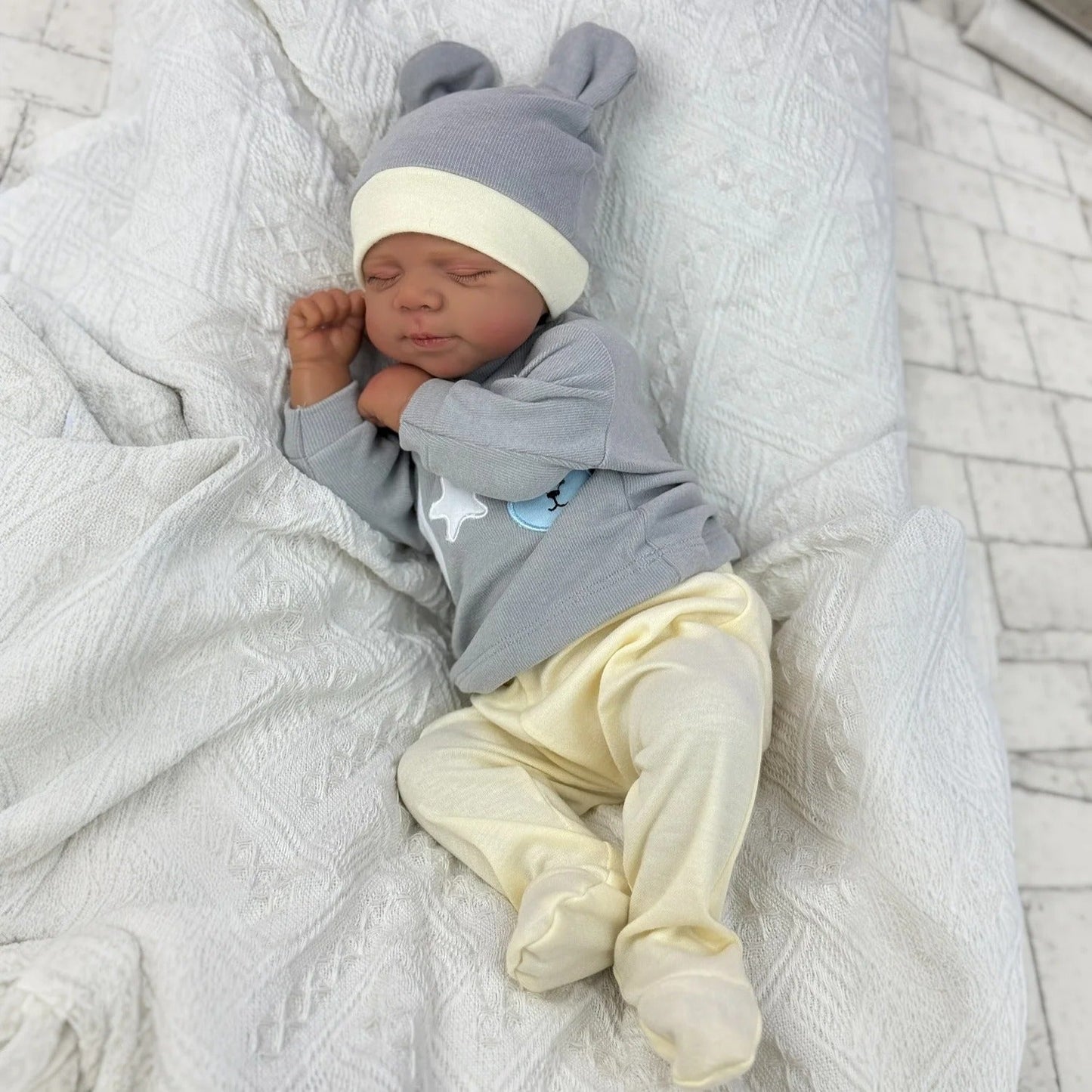 Bambola Reborn Pascale da 48 cm corpo morbido e realistico occhi chiusi pelle scura