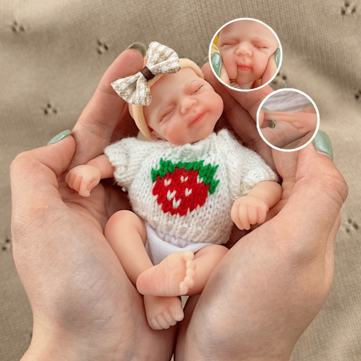Bambola reborn Pascale in silicone da 15 cm con occhi chiusi e maglione bianco a fragole
