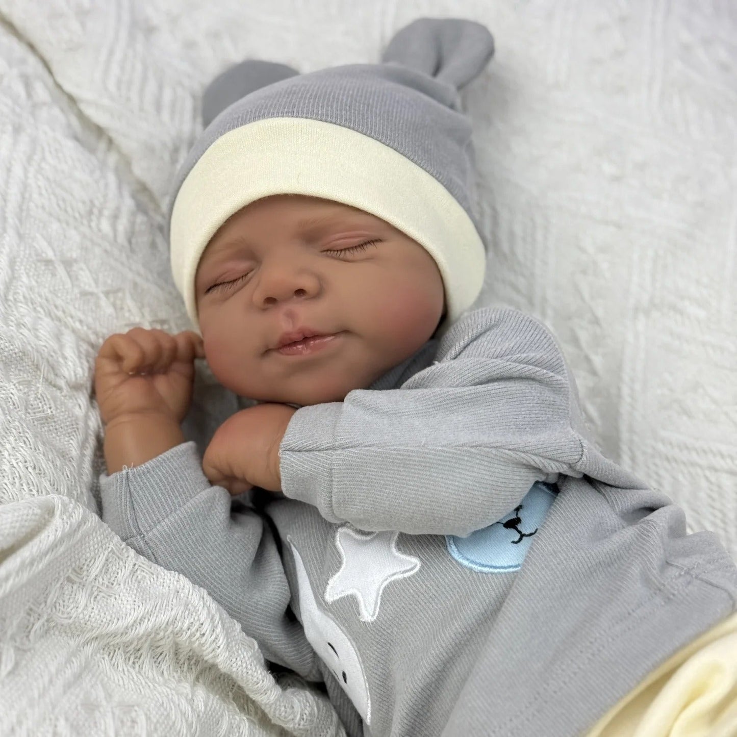 Bambola Reborn Pascale da 48 cm corpo morbido e realistico occhi chiusi pelle scura