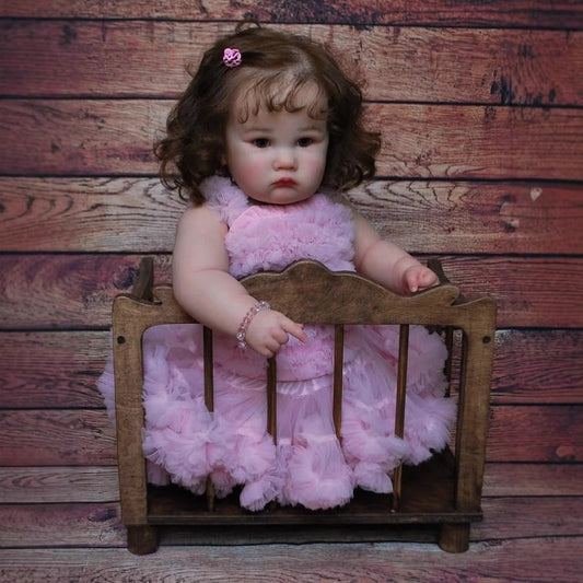 Bambola Reborn Charlotte da 60 cm con occhi aperti e capelli castani in abito rosa