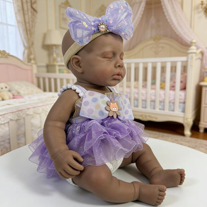 Bambola reborn Loulou in silicone 30cm realistica con pelle scura e vestito viola addormentata