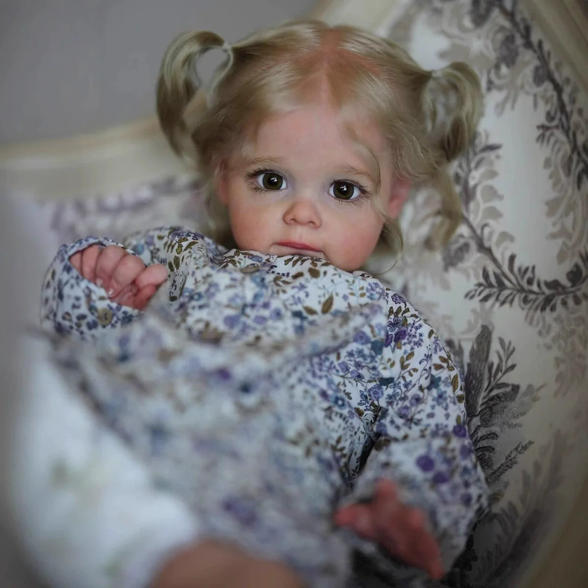 Bambola Reborn Maggie con Capelli Biondi e Occhi Aperti da 60 cm in Abiti Floreali