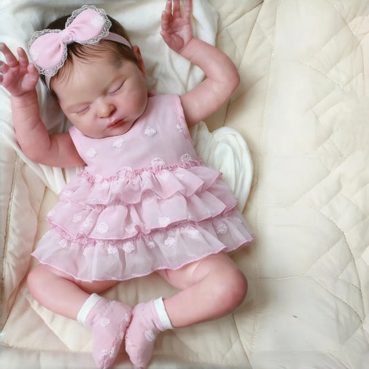 Bambina reborn Laura 50 cm realistica con occhi chiusi e capelli corti vestita di rosa
