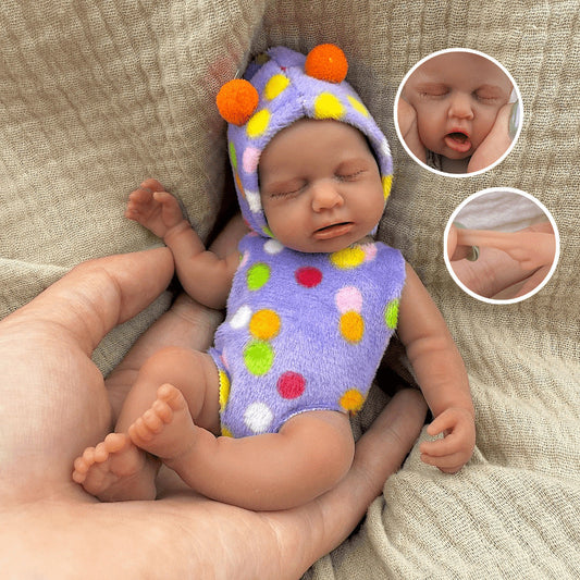 Bambola reborn Loulou in silicone da 15 cm con pelle scura e vestitino a pois