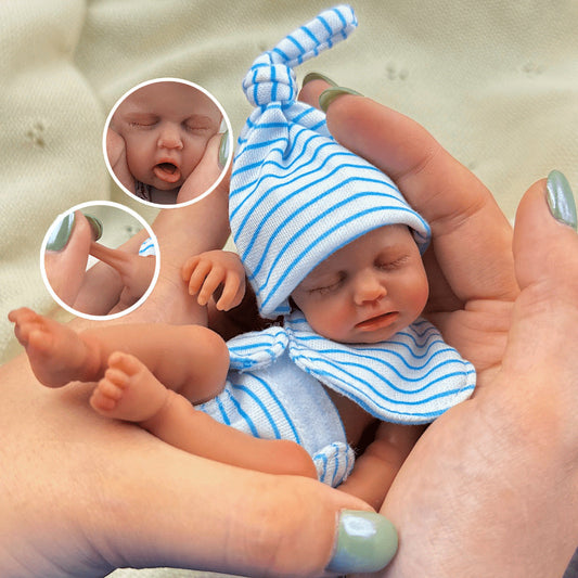 Bambola reborn Loulou Mini in silicone da 15 cm con pelle scura e vestito a righe blu