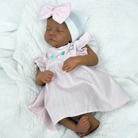 Bambole Reborn Levi 48 cm occhi chiusi pelle scura corpo morbido in abito rosa