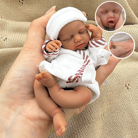 Bambola reborn Loulou Mini in silicone da 15 cm con pelle scura e accappatoio bianco