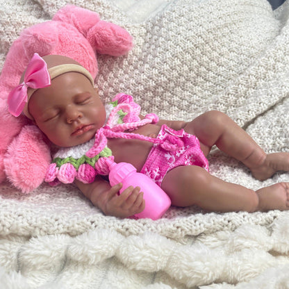 Bambola reborn Loulou in silicone realistica alta 30cm con pelle scura e vestiti rosa vestita da bambina addormentata