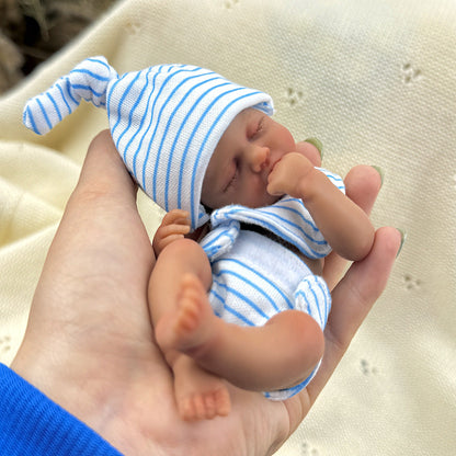 Bambola reborn Loulou Mini in silicone da 15 cm con pelle scura e vestito a righe blu