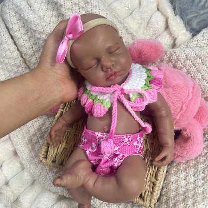 Bambola reborn Loulou in silicone realistica alta 30cm con pelle scura e vestiti rosa vestita da bambina addormentata