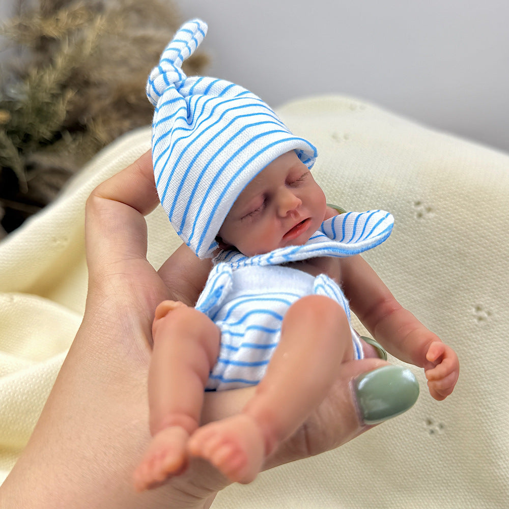 Bambola reborn Loulou Mini in silicone da 15 cm con pelle scura e vestito a righe blu