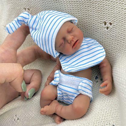 Bambola reborn Loulou Mini in silicone da 15 cm con pelle scura e vestito a righe blu