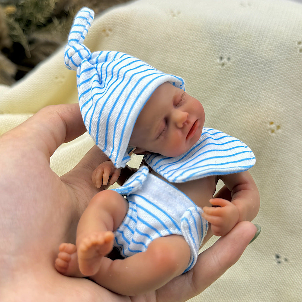 Bambola reborn Loulou Mini in silicone da 15 cm con pelle scura e vestito a righe blu