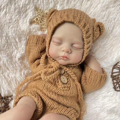 Bambola reborn Irys da 19 pollici con occhi chiusi e pittura 3D vestita con abiti di maglia marrone