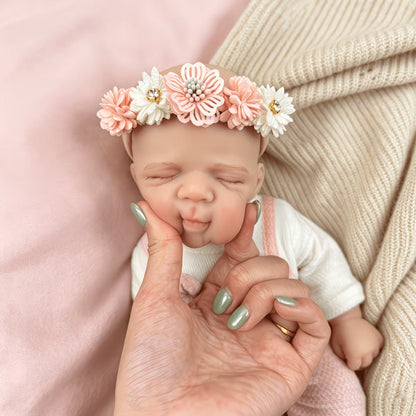 Bambola reborn Pascale da 30 cm in silicone addormentata con indosso un vestitino da orsetto rosa