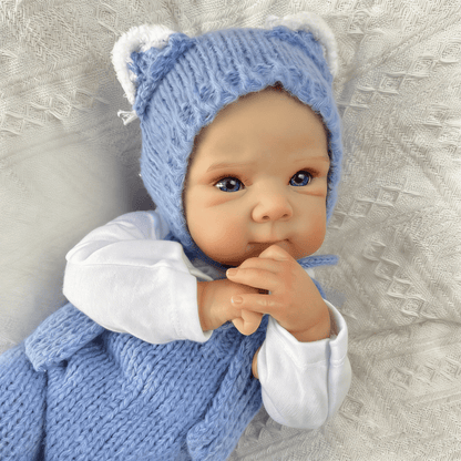 Bambola reborn Bettie da 45cm con occhi azzurri vestita con un body blu lavorato a maglia