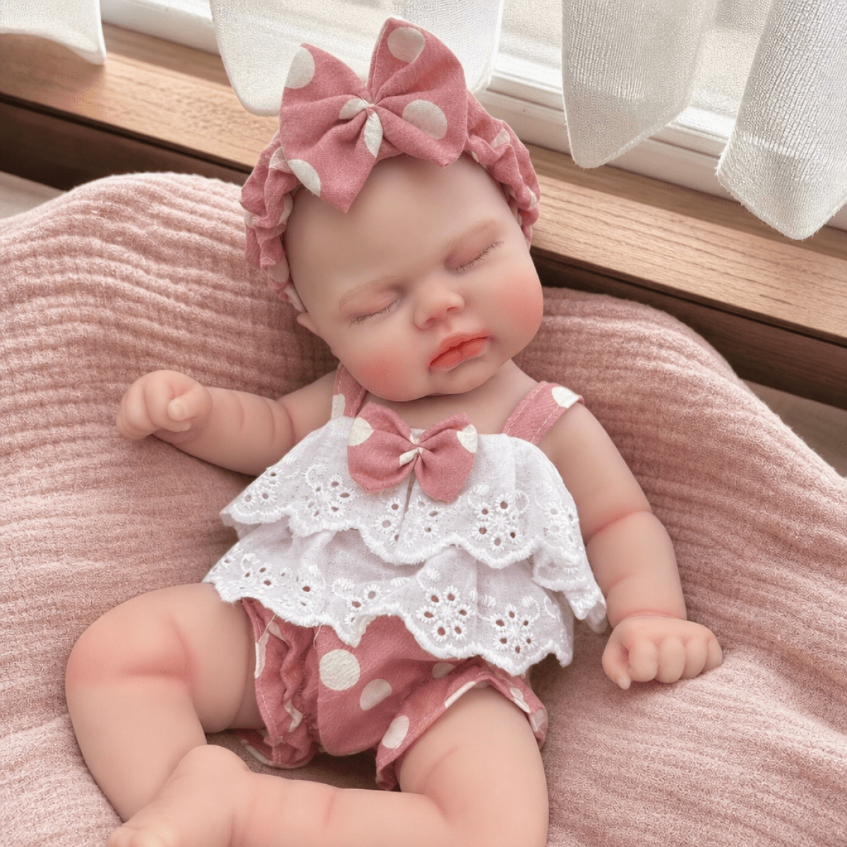 Bambola reborn realistica in morbido silicone alta 30cm con vestitino a pois rosa