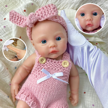 Bambina reborn Meadow in silicone integrale da 30 cm con tutina rosa in maglia