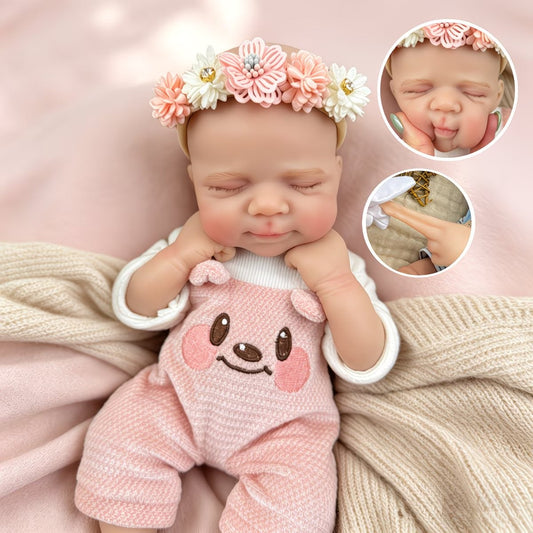 Bambola reborn Pascale da 30 cm in silicone addormentata con indosso un vestitino da orsetto rosa
