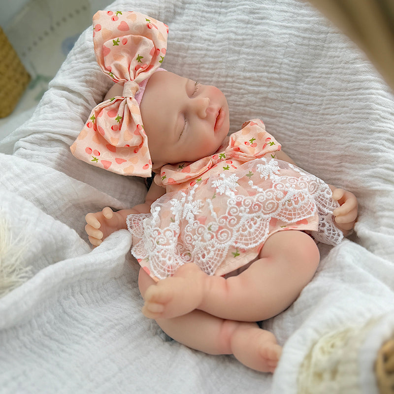 Bambola Reborn femmina Loulou da 30 cm in silicone pieno (occhi chiusi) con vestitino in pizzo a fantasia di ciliegie