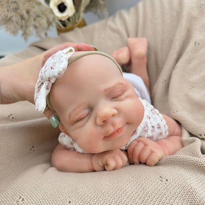 Bambola Reborn Pascale da 45 cm in silicone pieno flessibile dormiente con bavaglino a fiori