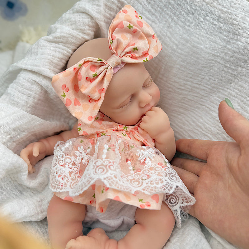 Bambola Reborn femmina Loulou da 30 cm in silicone pieno (occhi chiusi) con vestitino in pizzo a fantasia di ciliegie