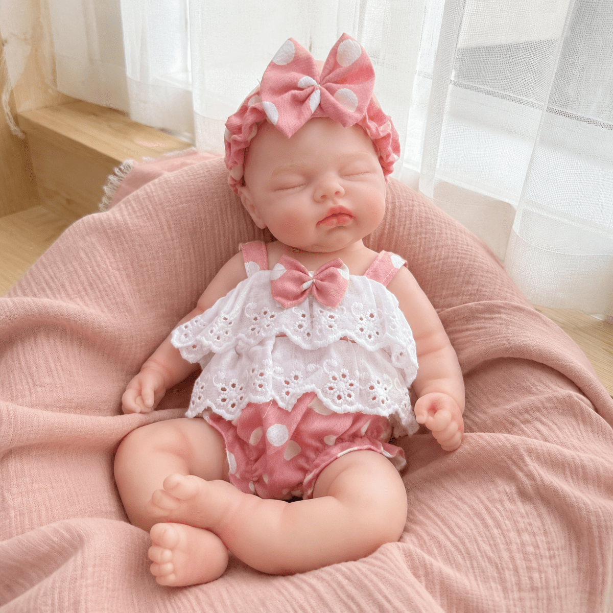 Bambola reborn realistica in morbido silicone alta 30cm con vestitino a pois rosa