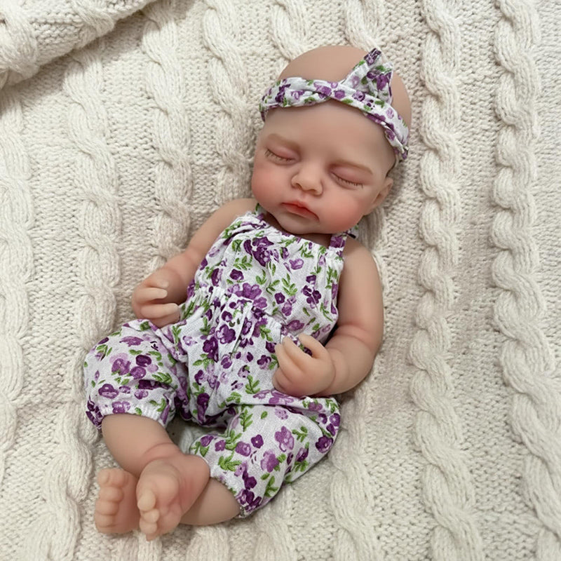 Bambola reborn Irys da 30cm interamente in silicone con tutina floreale viola
