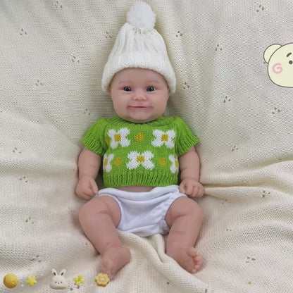 Bambola reborn Maddie Smile da 30 cm interamente in silicone con vestitino verde