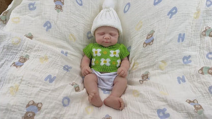 Bambola reborn Pascale in silicone da 30 cm addormentata con indosso un vestitino di maglia verde
